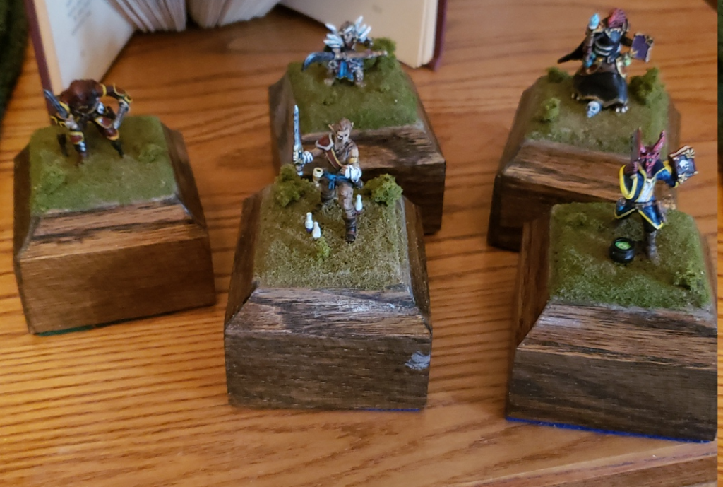 5 hero forge minis, from left to right: high elf rogue, wood elf monk, teifling witch, halfling ranger, dragonborn warlock